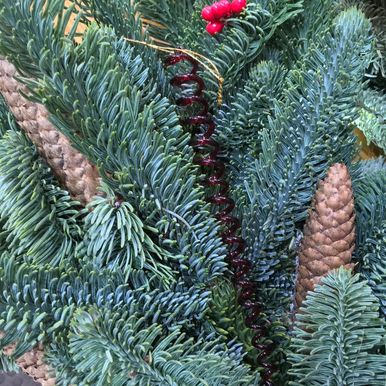 A red glass spiral which catches the light on the Christmas tree