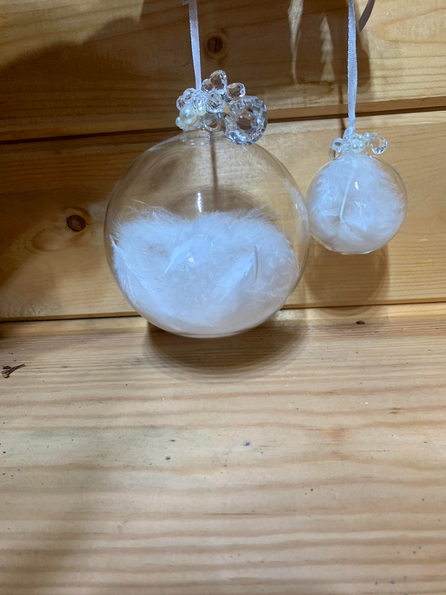 Lovely large clear round bauble shaped glass hanging Christmas decoration with a white feather inside and delicate beading on the top.