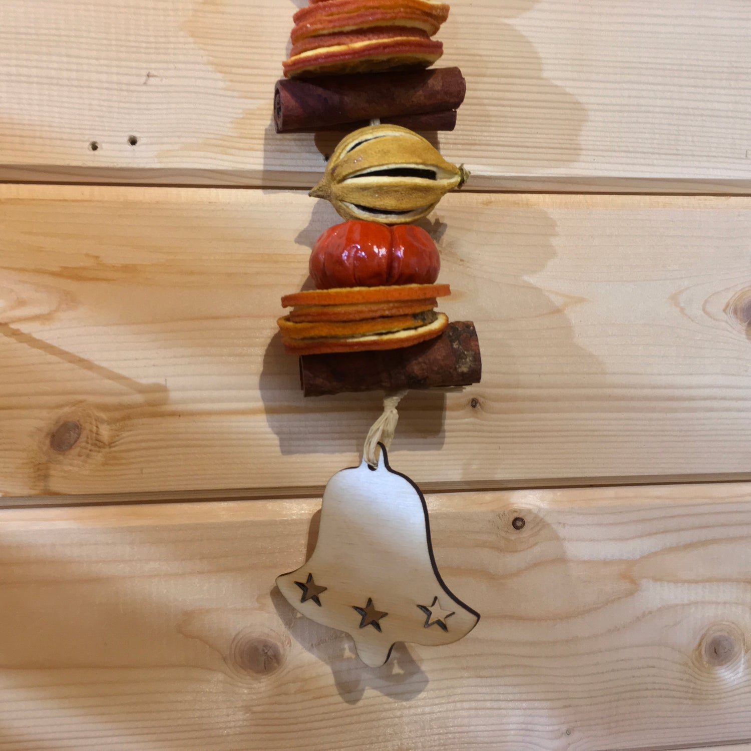Deliciously fragrant lemon and orange hanging garland with a wooden bell decoration.