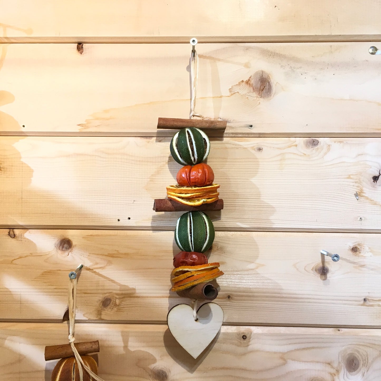Deliciously fragrant lime and orange hanging garland with a wooden heart decoration.
