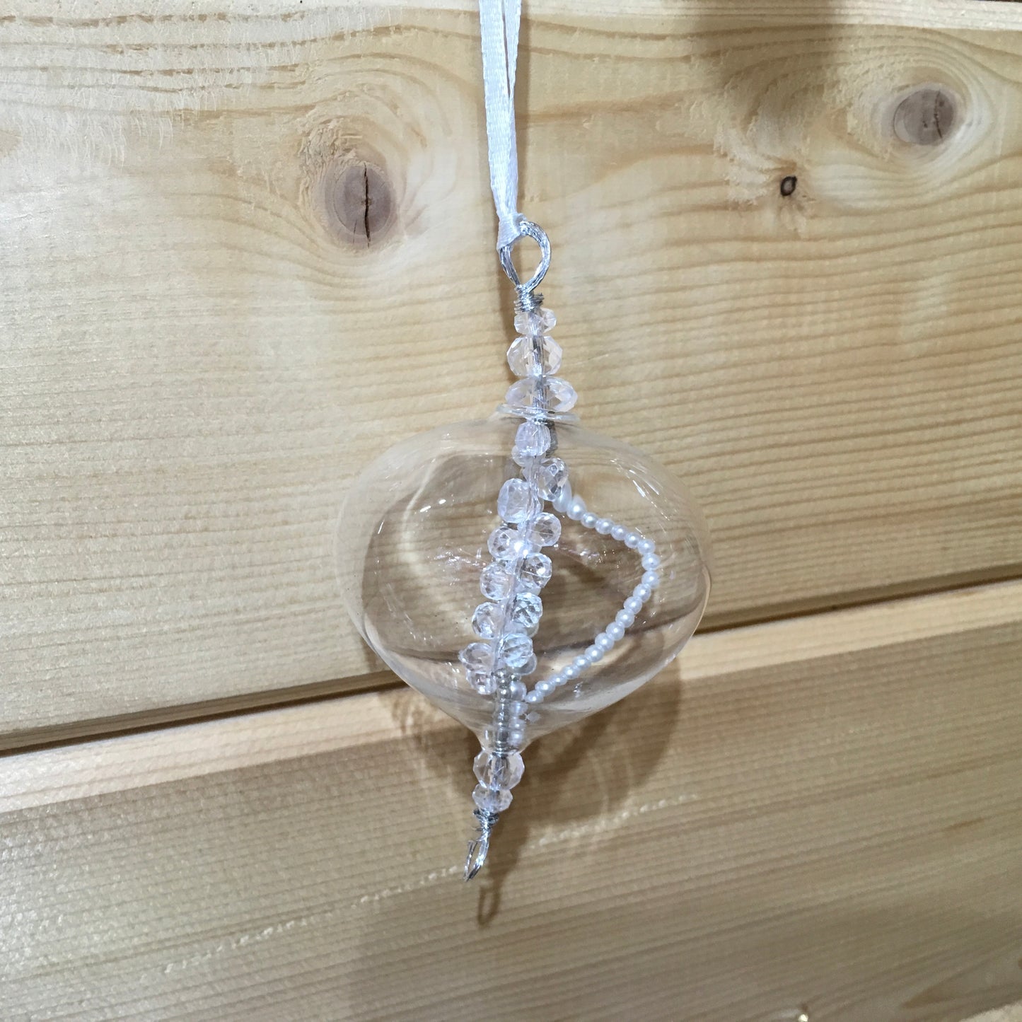 Delicate small clear glass decoration with strings of clear and pearl beads inside which catch the light.