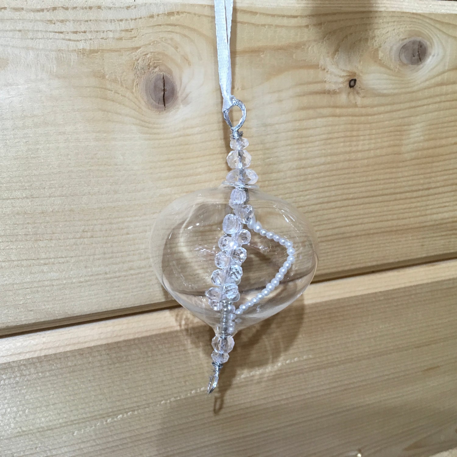 Delicate small clear glass decoration with strings of clear and pearl beads inside which catch the light.