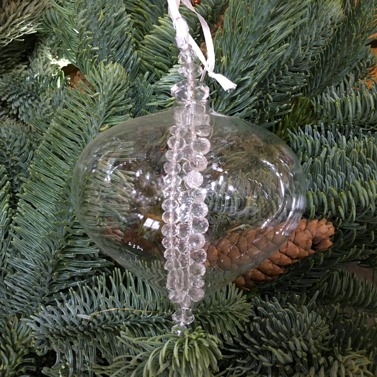 Clear glass sultan decoration with strings of clear glass beads inside which twinkle on the Christmas tree.