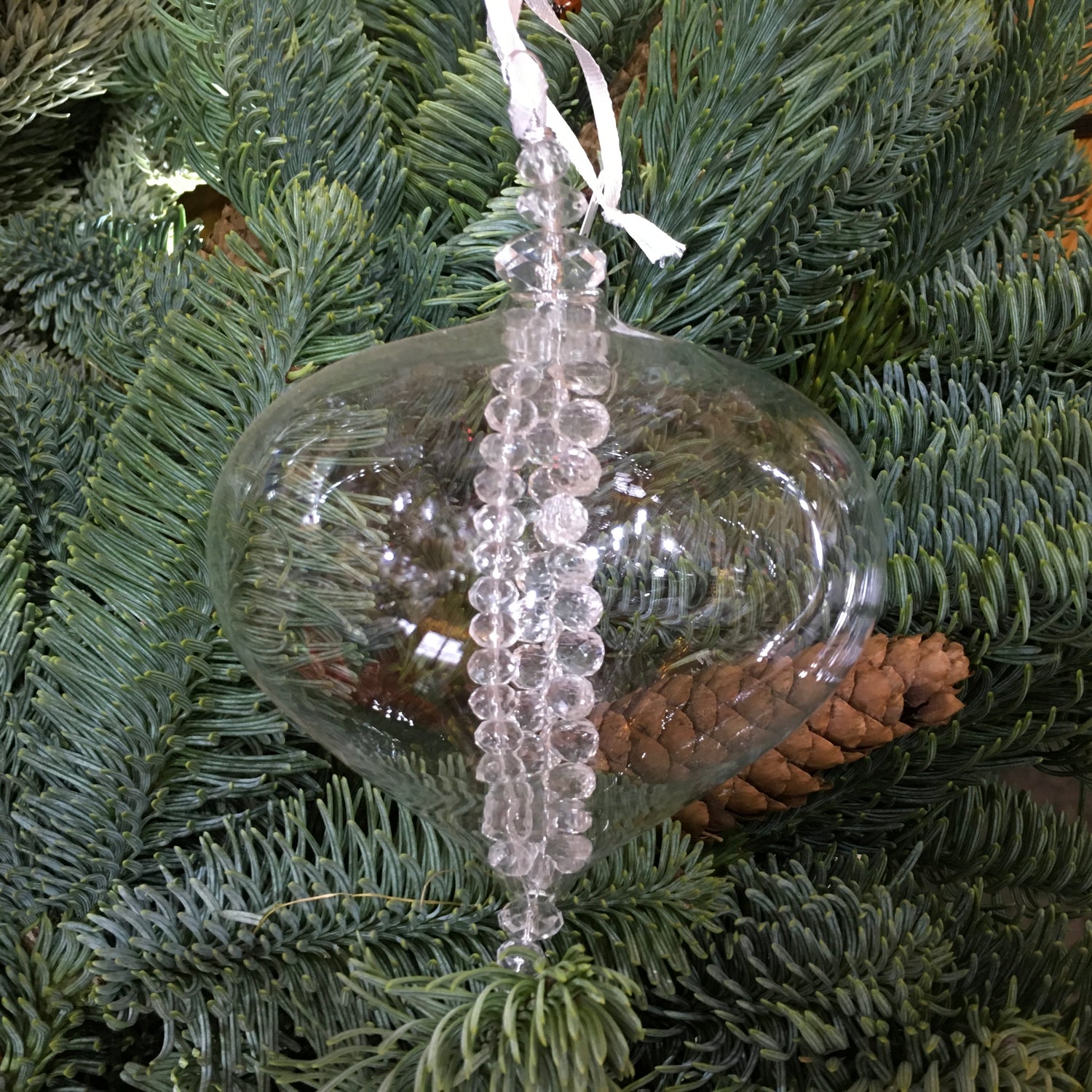 Clear glass sultan decoration with strings of clear glass beads inside which twinkle on the Christmas tree.
