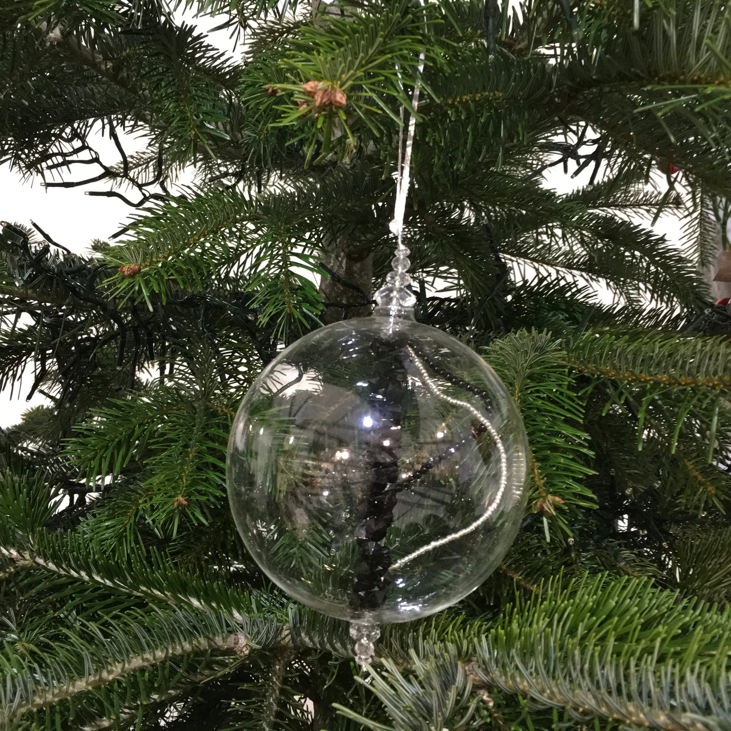 Handmade blown glass sphere filled with strings of black, clear and silver beads