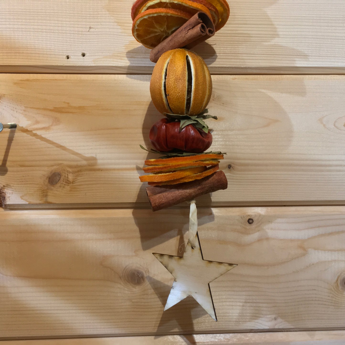 Deliciously fragrant orange and cinnamon hanging garland with a wooden star decoration.
