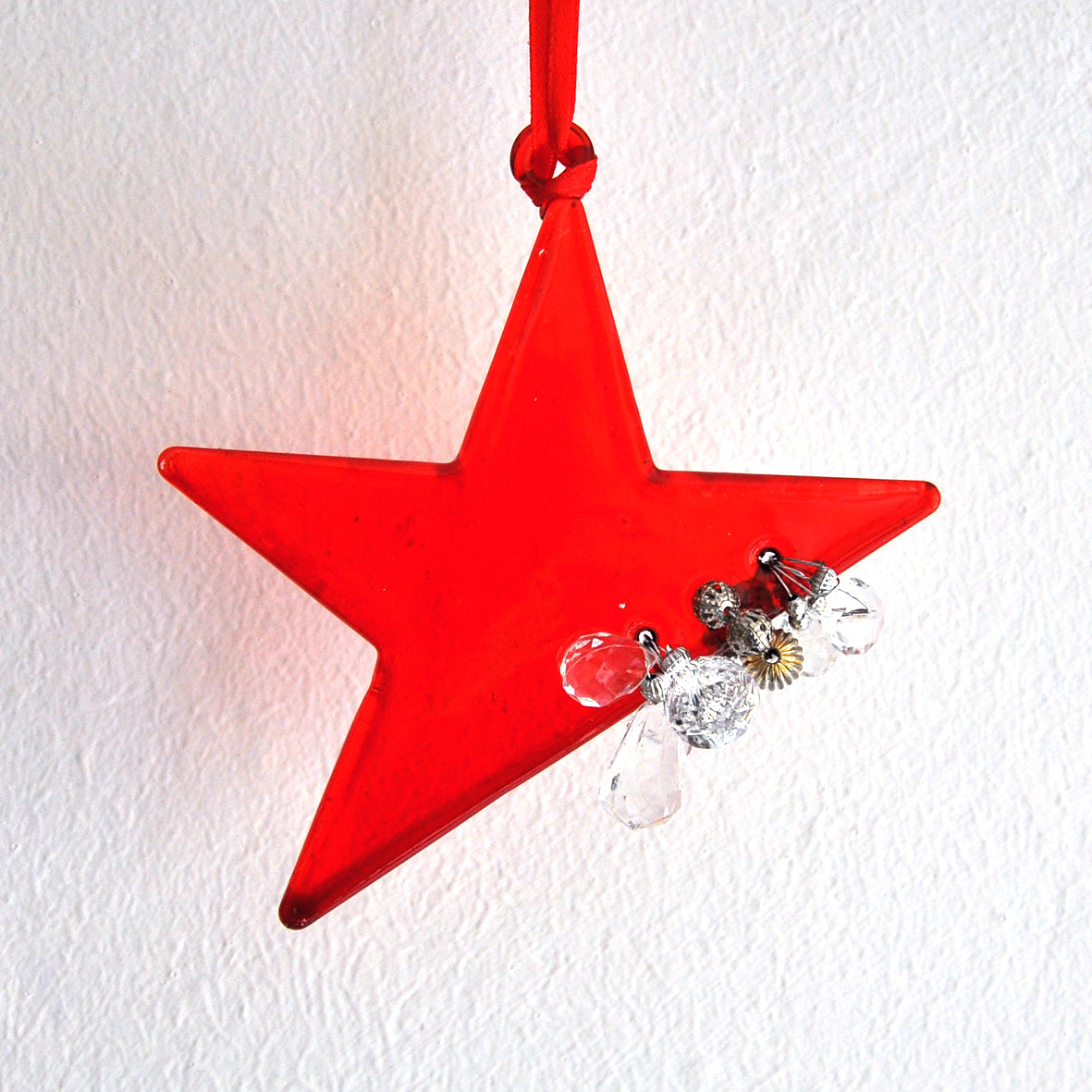 This bright red star ornament is made from glass and decorated with beads.