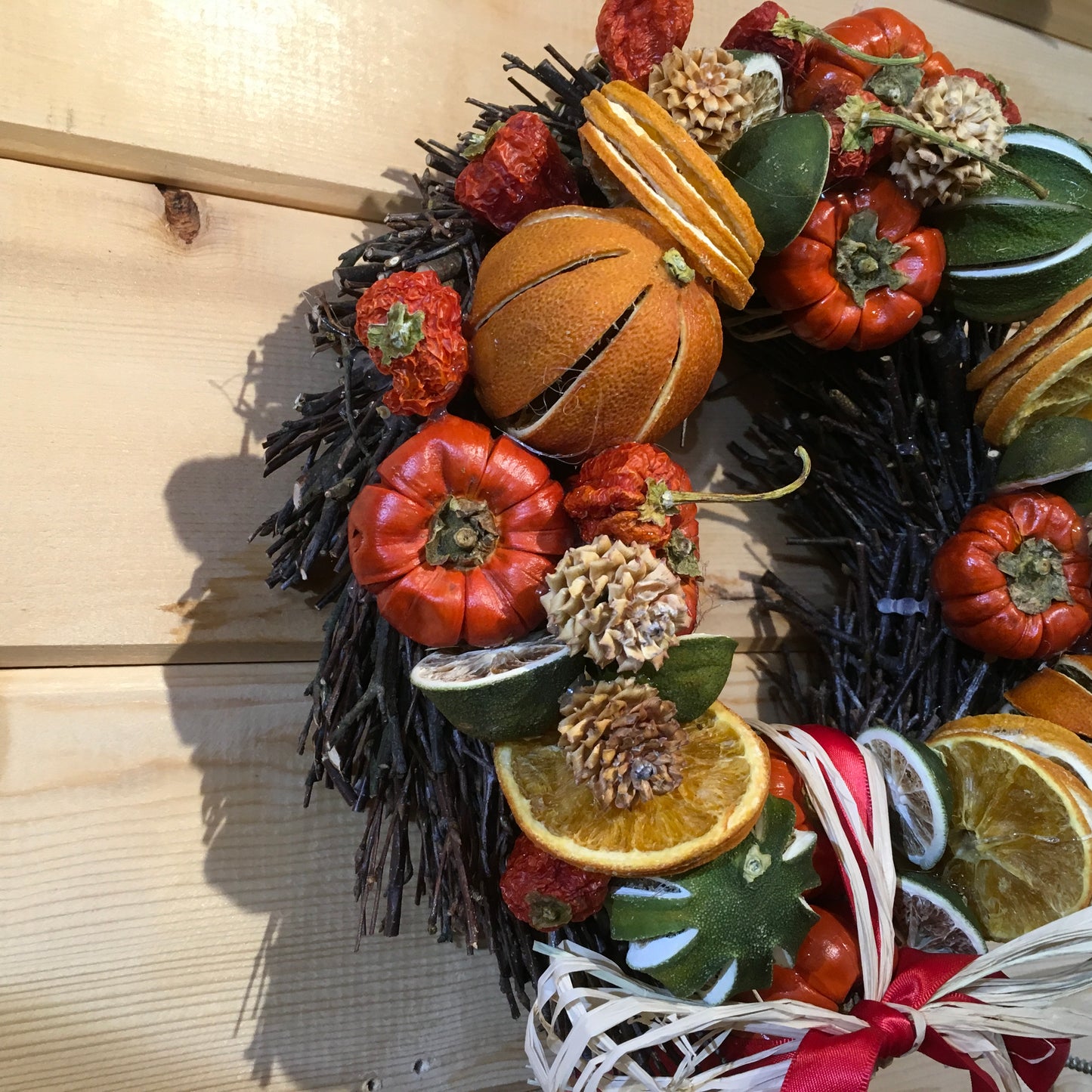 Circle shaped twig wreath that has been beautifully decorated with an assortment of dried fruits, cinnamon sticks and pine cones, and scented with a wonderful Christmas fragrance. With an additional decorative red bow and hanger.