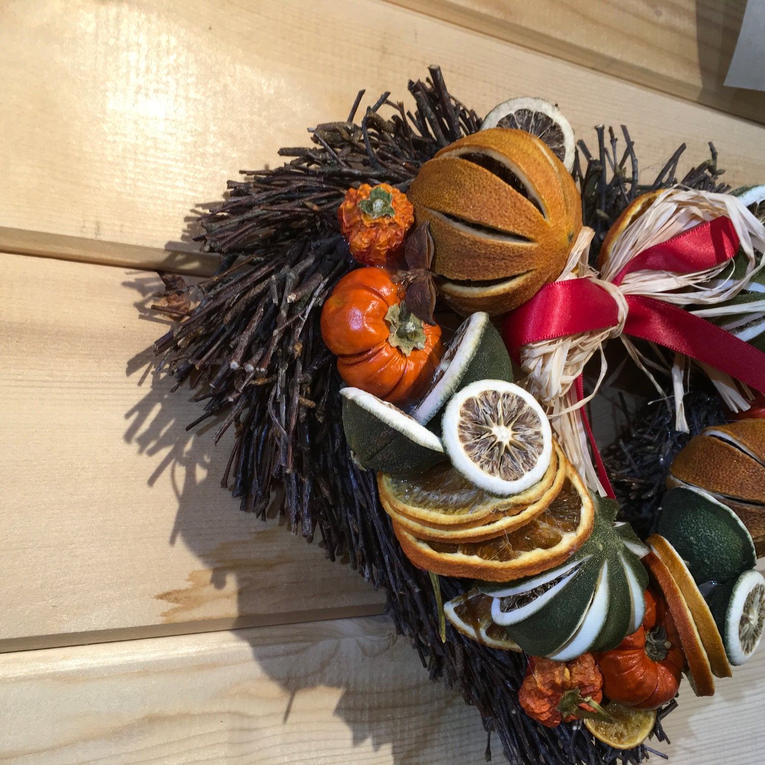 Heart shaped twig wreath that has been beautifully decorated with an assortment of dried fruits, and cinnamon sticks and scented with a wonderful Christmas fragrance. With an additional decorative red bow and hanger.