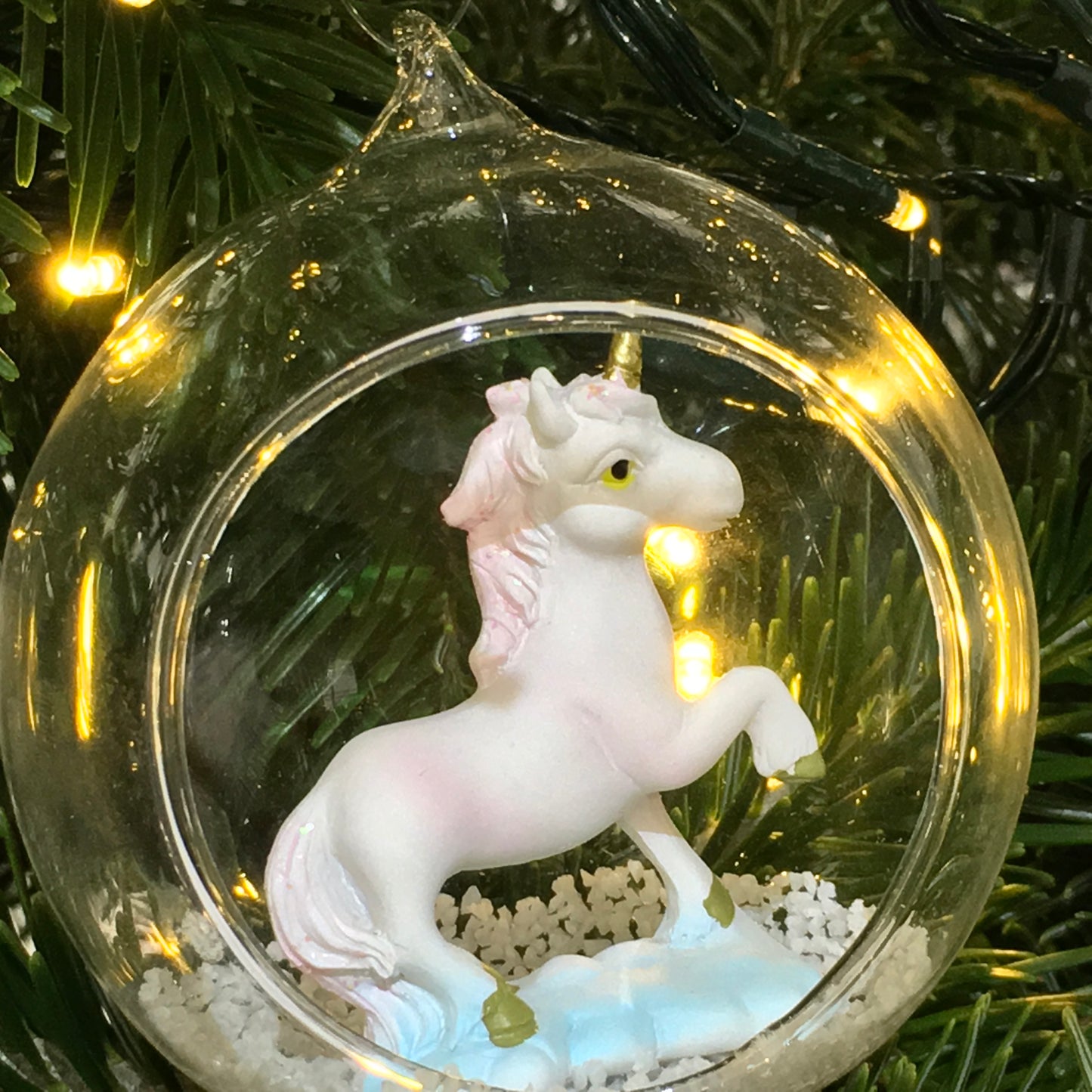 A beautiful open glass bauble Christmas tree decoration, with a glittery unicorn inside.