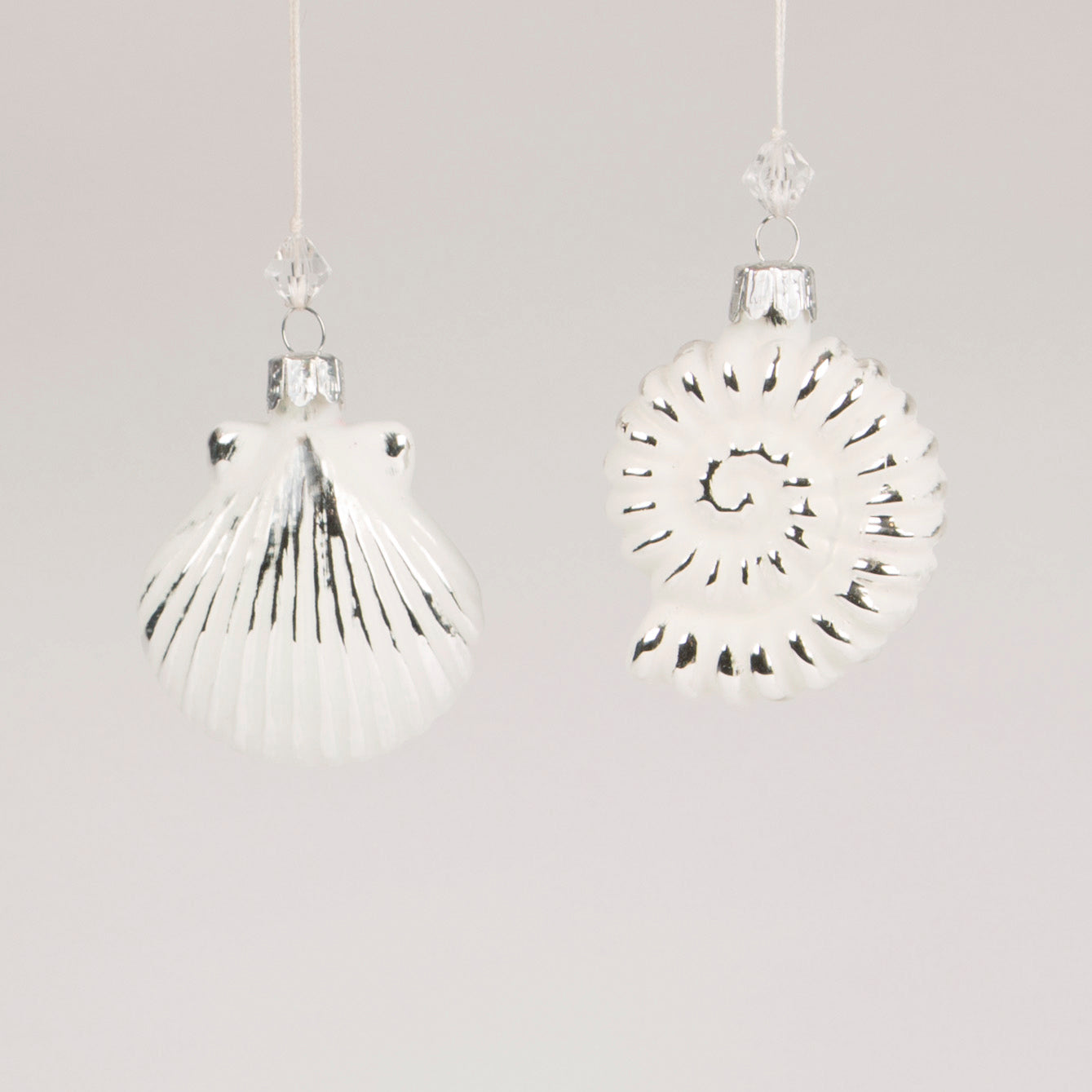 A white seashell hanging decoration to hang on your Christmas Tree or around the home for a winter wonderland feel. Choose between a 'spiral' or 'clam' shape shell.
