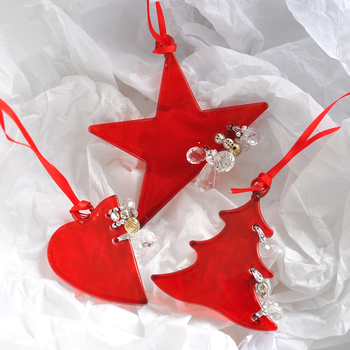 ​This bright red star ornament is made from glass and decorated with beads.