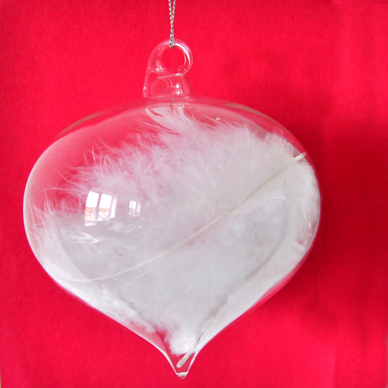 Clear glass sultan Christmas decoration with real white feathers inside