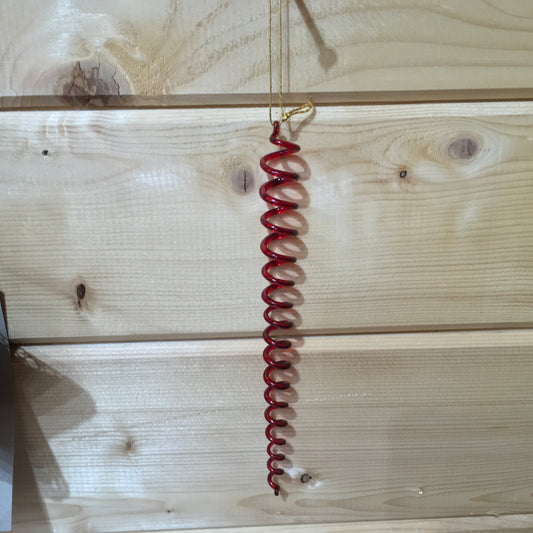 A red glass spiral which catches the light on the Christmas tree