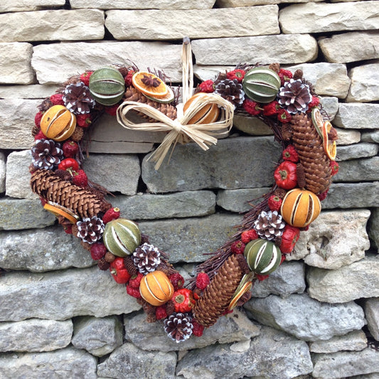 Large heart wreath made from willow with high quality dried festive orange green and red fruit plus cones.