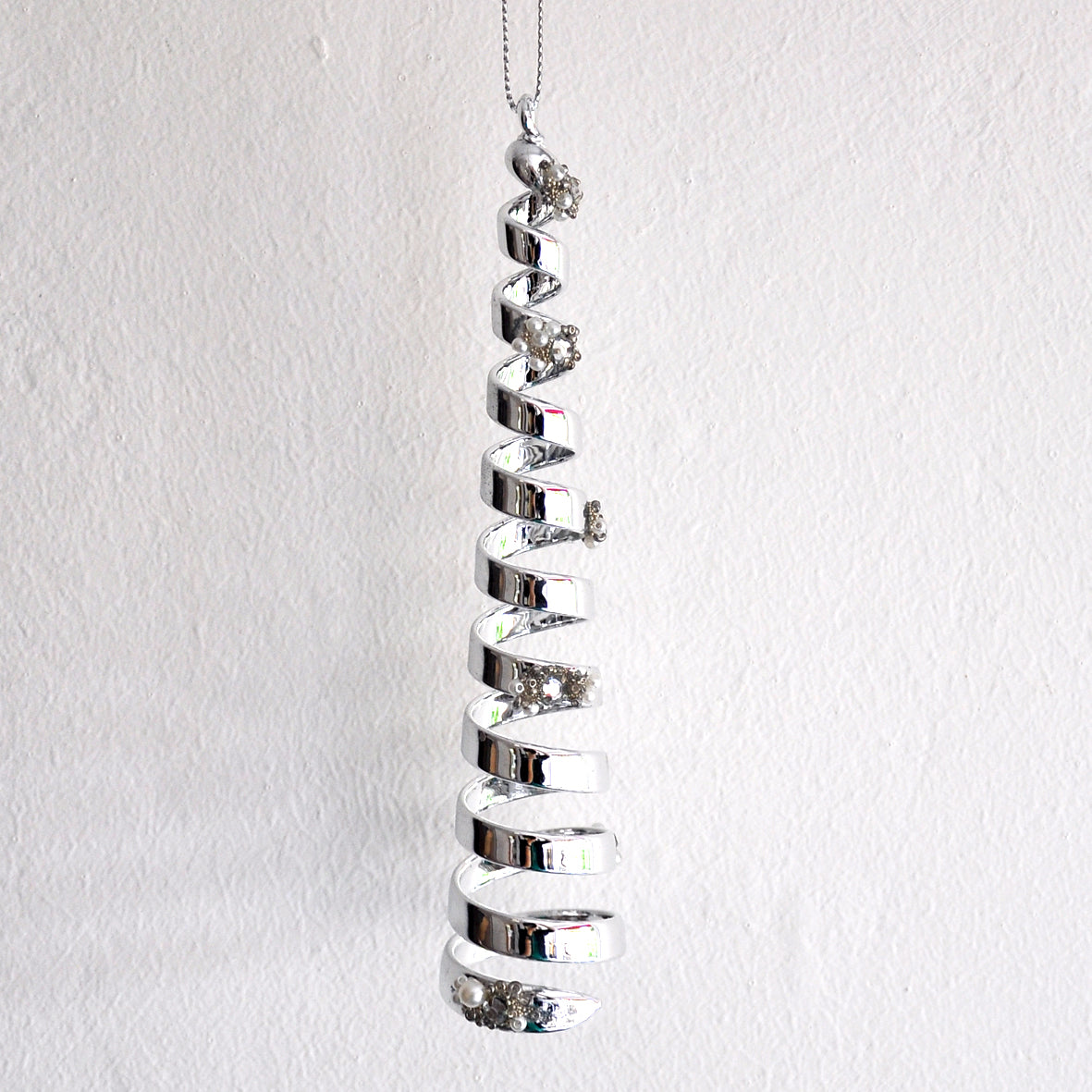This striking silver spiral is made from glass and decorated with diamonte, beads and pearls.
