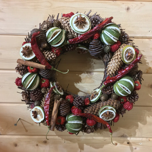 Red and green festive wreath made from dried lines and peppers for  Christmas