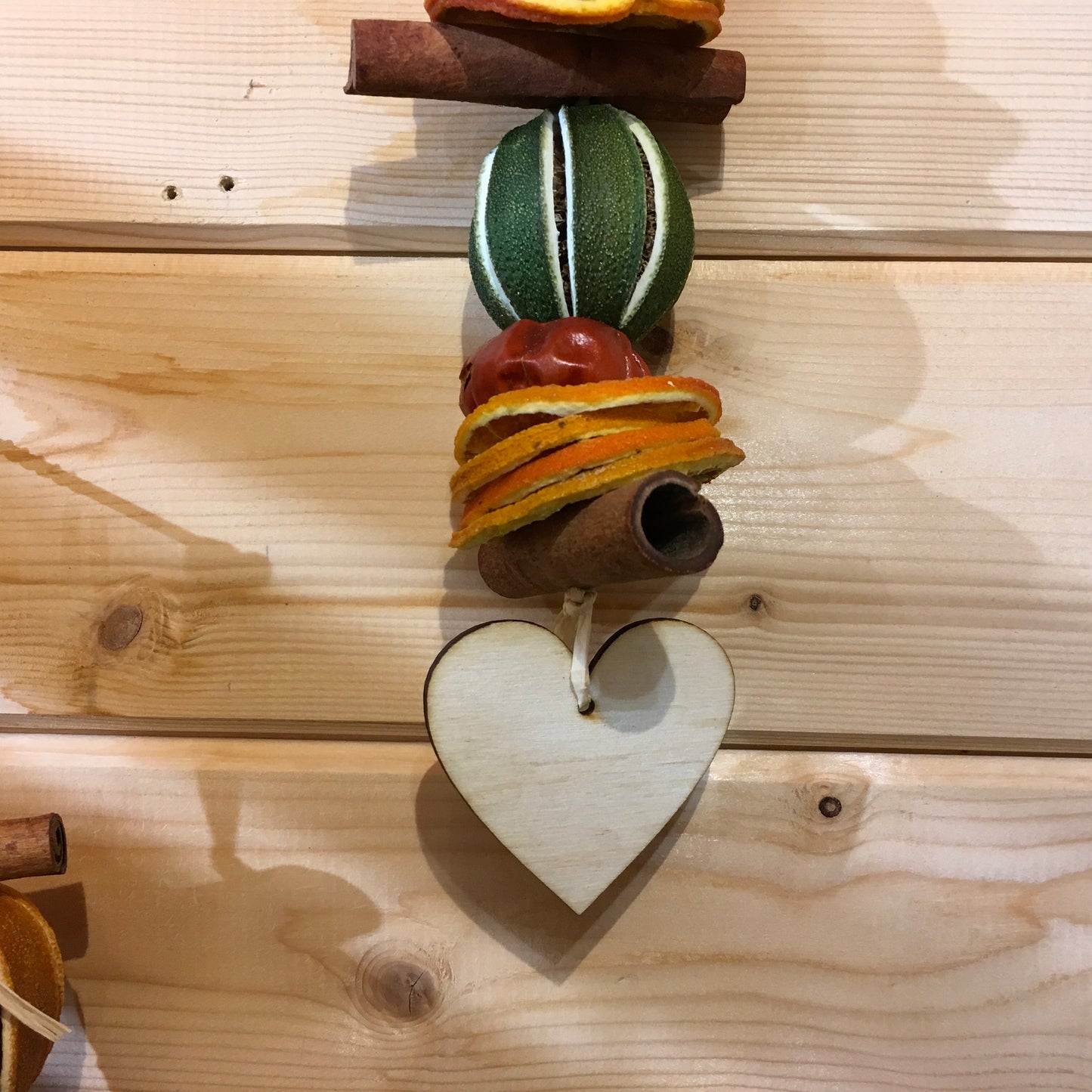 Deliciously fragrant lime and orange hanging garland with a wooden heart decoration.
