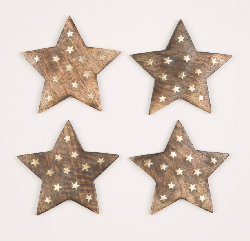 A set of 4 star shaped coasters made from mango wood with mini star shape brass inlays - perfect for creating a cosy winter woodland wonderland feel.