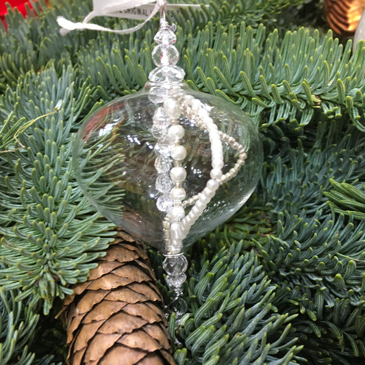 Delicate small clear glass decoration with strings of clear and pearl beads inside which catch the light.