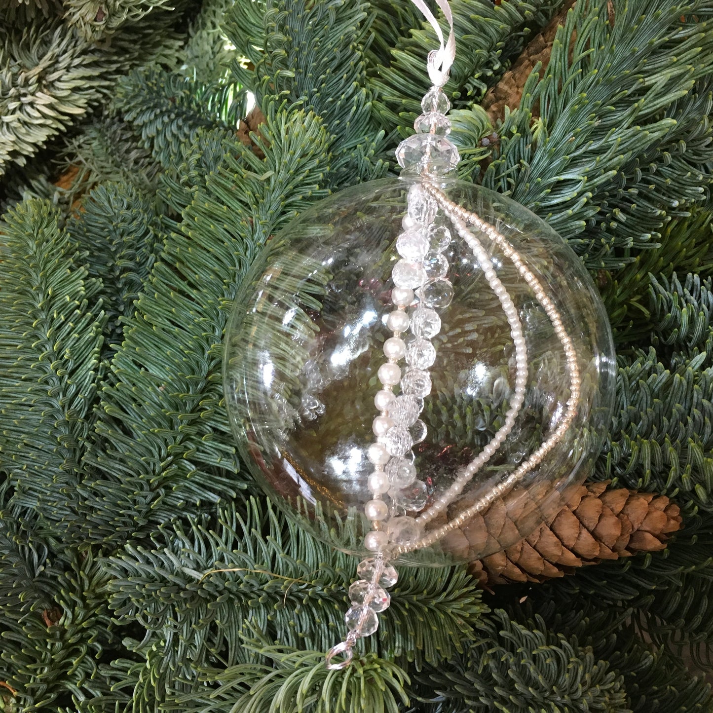 This flat sphere glass decoration is full of strings of clear, pearl and silver beads which sparkle on the Christmas tree
