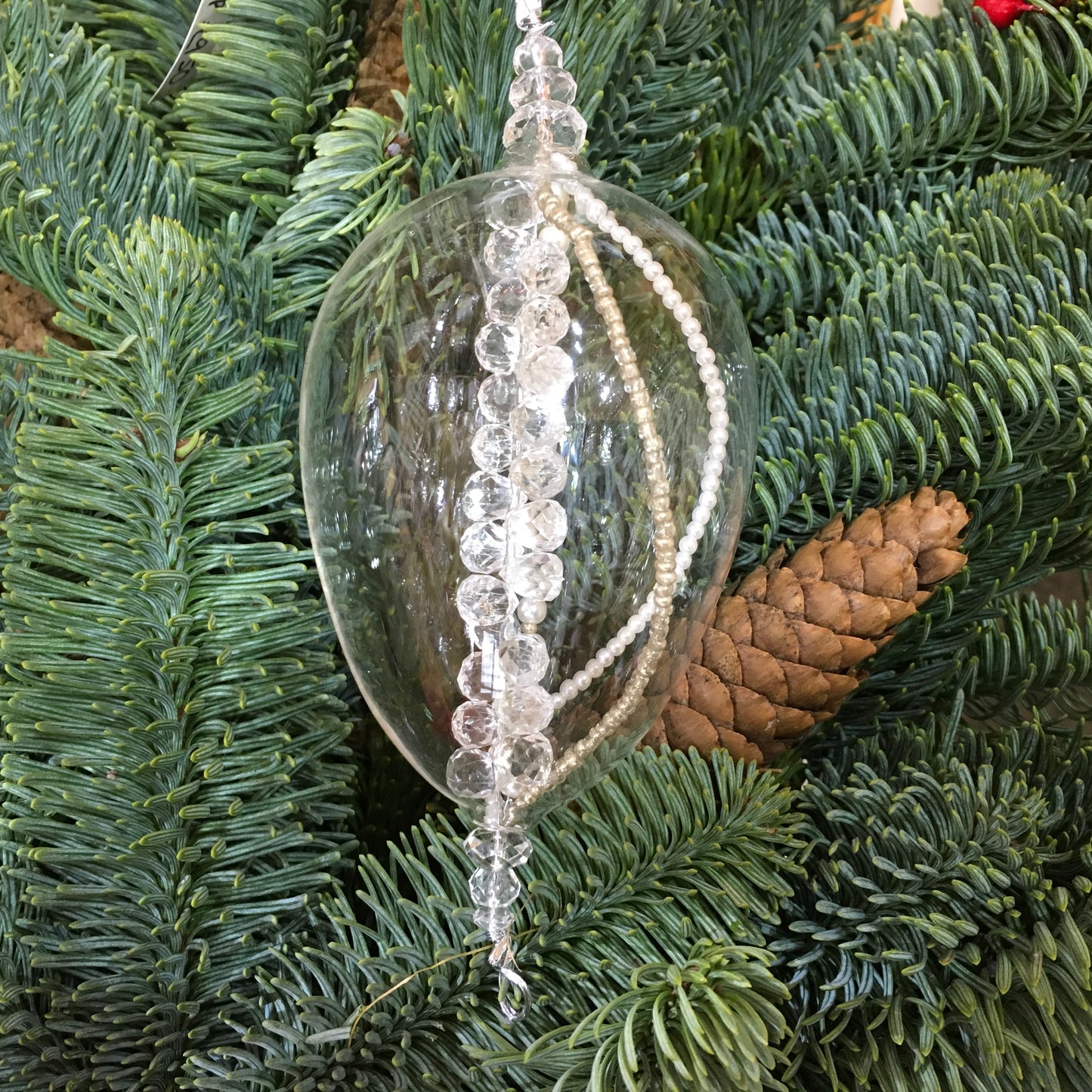 Clear egg-shaped decoration with strings of pearl, silver and glass beads that sparkle in the light