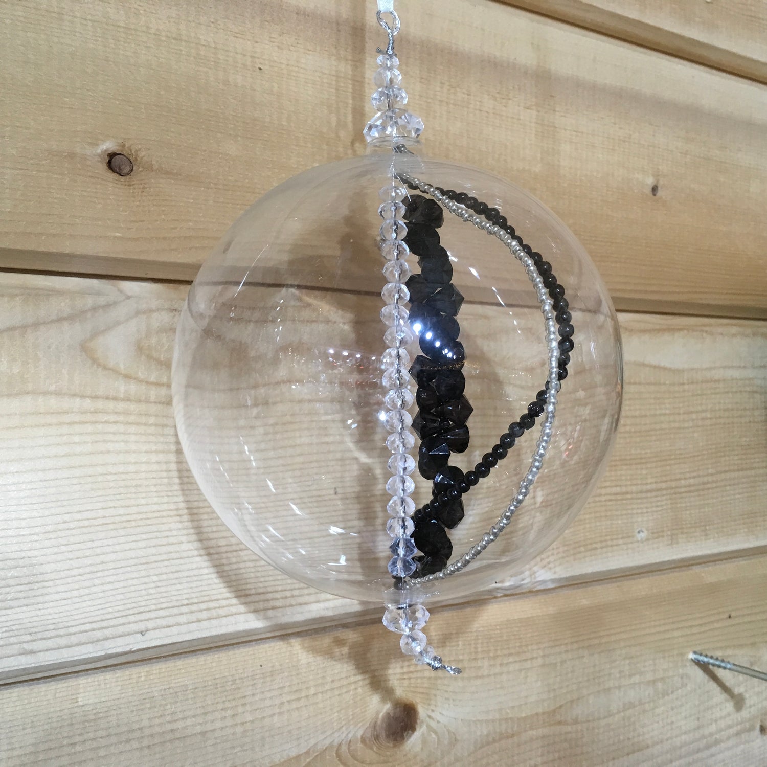 Handmade blown glass sphere filled with strings of black, clear and silver beads