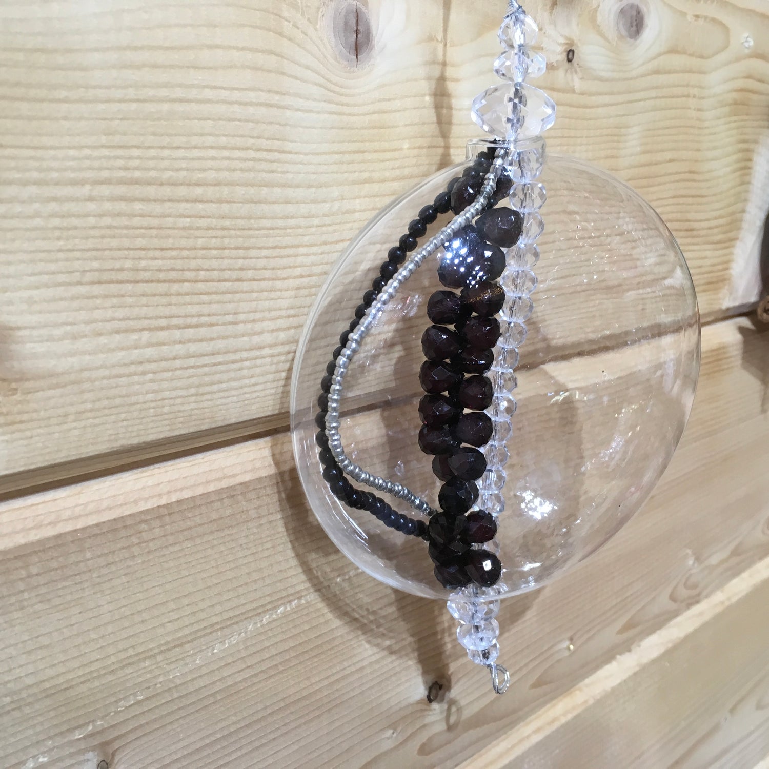 Flat clear glass decoration filled with sparkling black, silver and clear beads