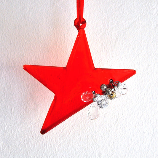 ​This bright red star ornament is made from glass and decorated with beads.