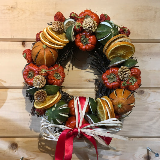 Circle shaped twig wreath that has been beautifully decorated with an assortment of dried fruits, cinnamon sticks and pine cones, and scented with a wonderful Christmas fragrance. With an additional decorative red bow and hanger.