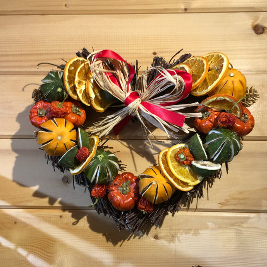 Stunning heart shaped twig wreath decorated with dried fruits, cinnamon sticks and pine cones.