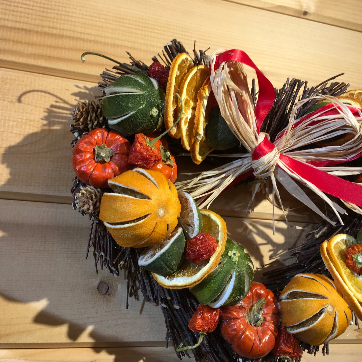 Stunning heart shaped twig wreath decorated with dried fruits, cinnamon sticks and pine cones.