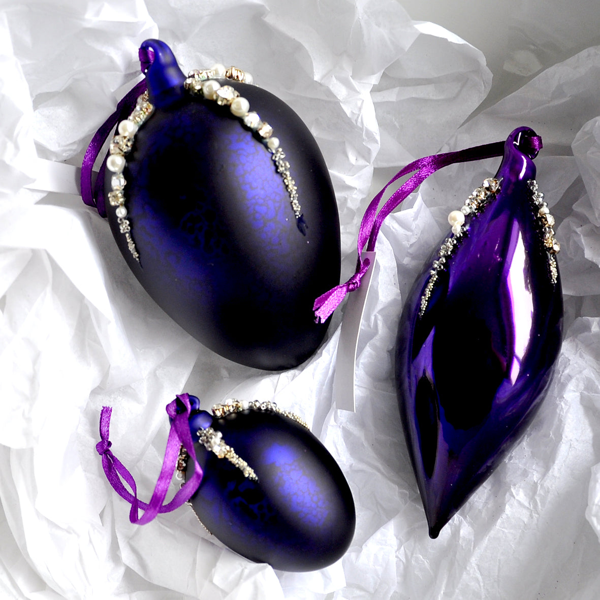 These matt aubergine purple egg shape Christmas ornament is made from glass and decorated with beads, pearls and diamonte.