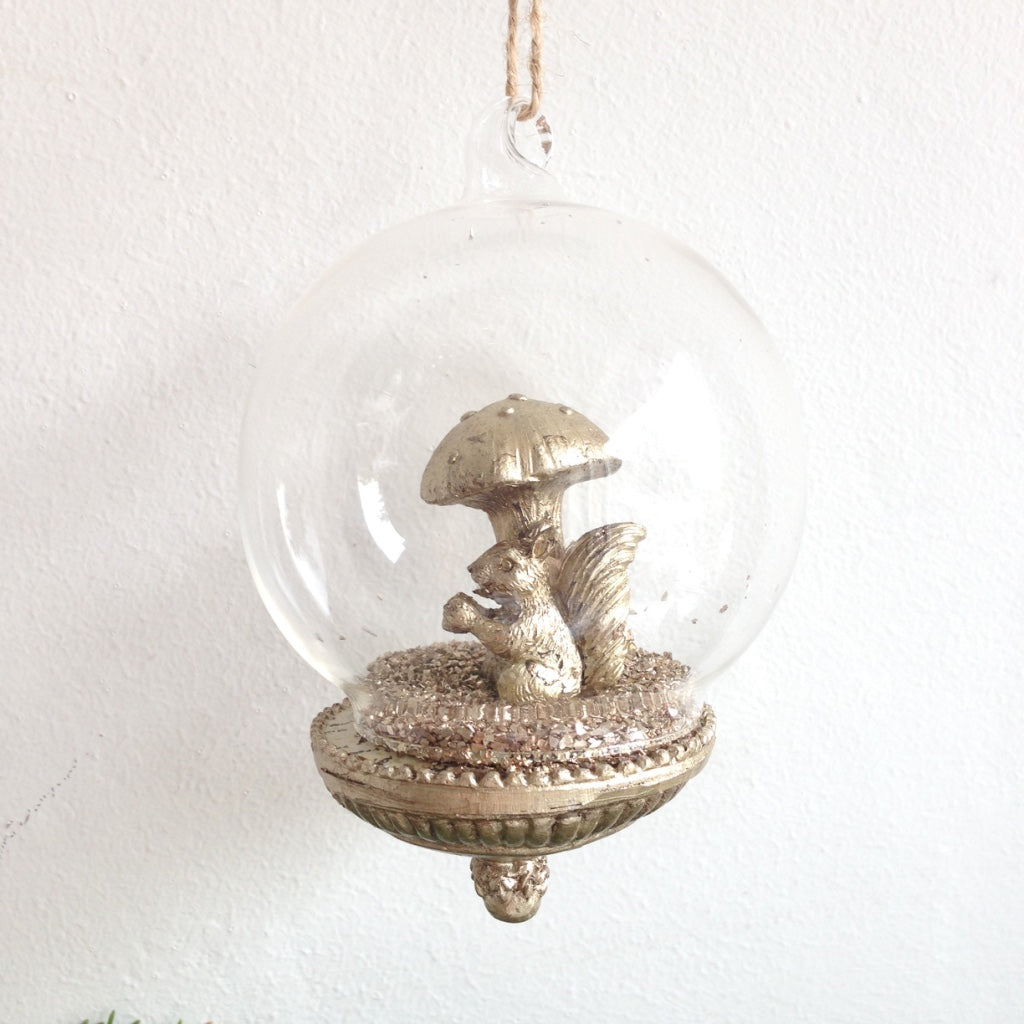 Gold squirrel and toadstool decoration inside a glass antique style bauble for Christmas Tree hanging ornament.