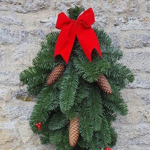 Natural noble fir decoration, door swag. This beautiful swag is made from non-drop noble fir boughs, which is decorated with real fir cones and faux berries, topped off with a classic Christmas red bow. Hang this on a door as an alternative to a wreath, or over a fireplace, suitable for indoor or outdoor use.
