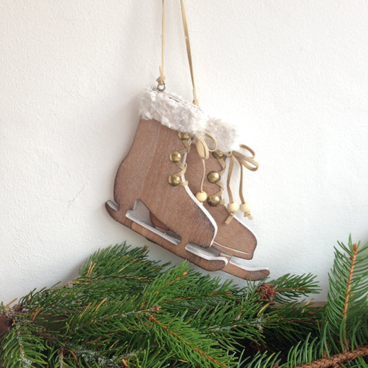 Natural wood and white pair of ice skates to hang on a christmas tree or in the festive home.