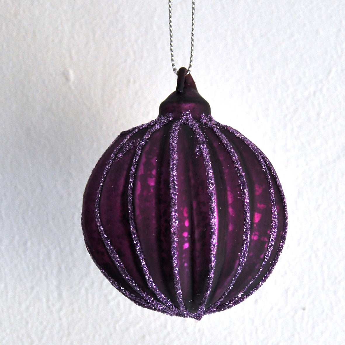 This glittery aubergine purple ridged Christmas bauble is made from glass.