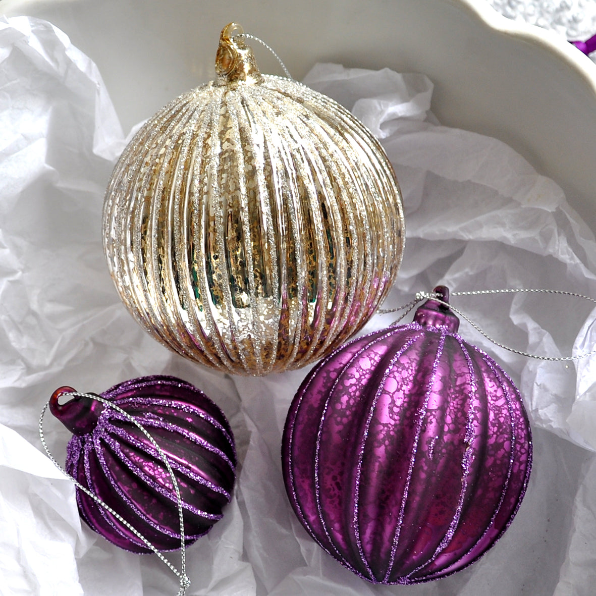 This glittery aubergine purple ridged Christmas bauble is made from glass.
