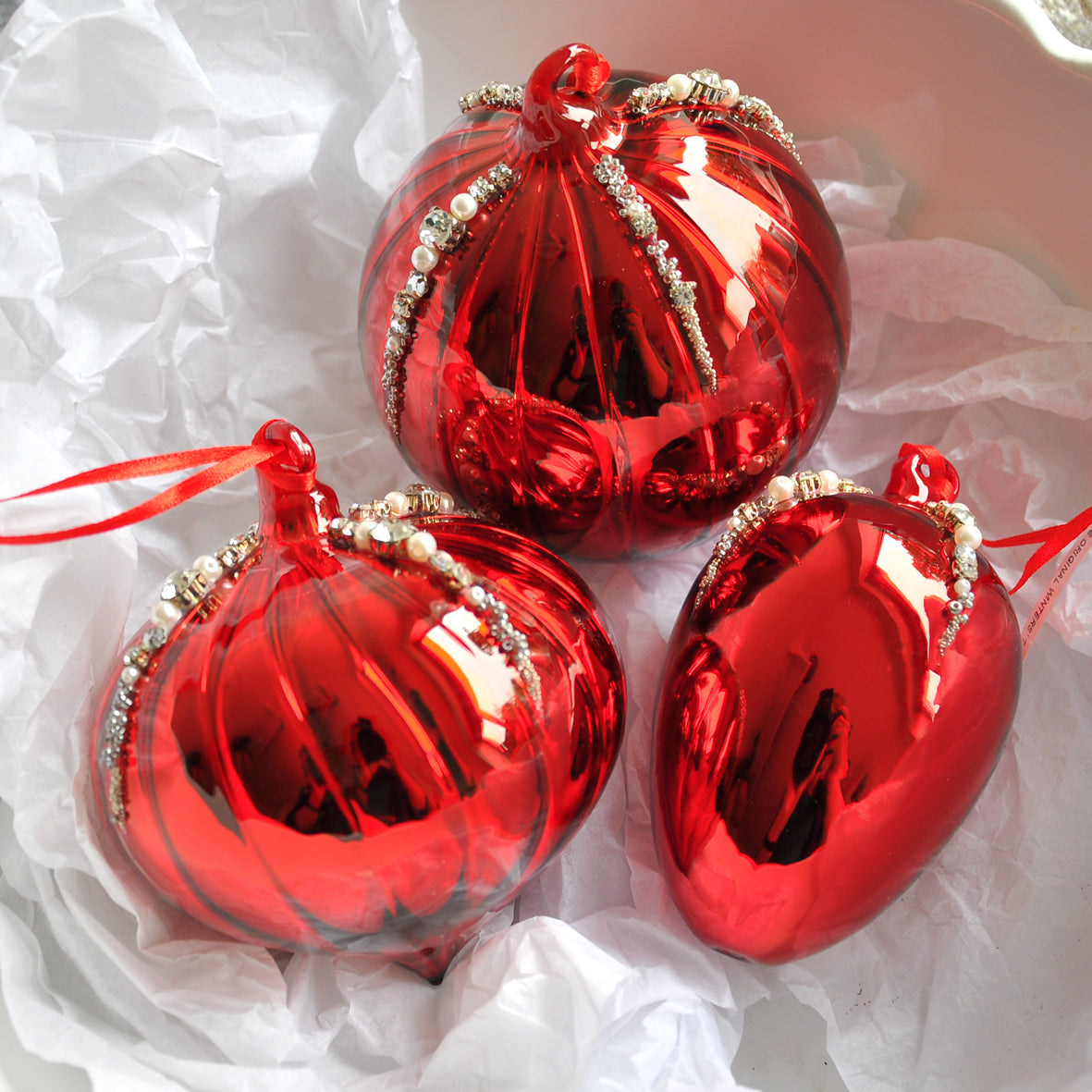 This red mirror egg shape Christmas ornament is made from glass and decorated with beads, pearls and diamonte.